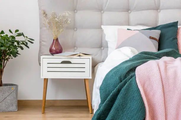 Modern bedside table with lamp in a stylish bedroom interior